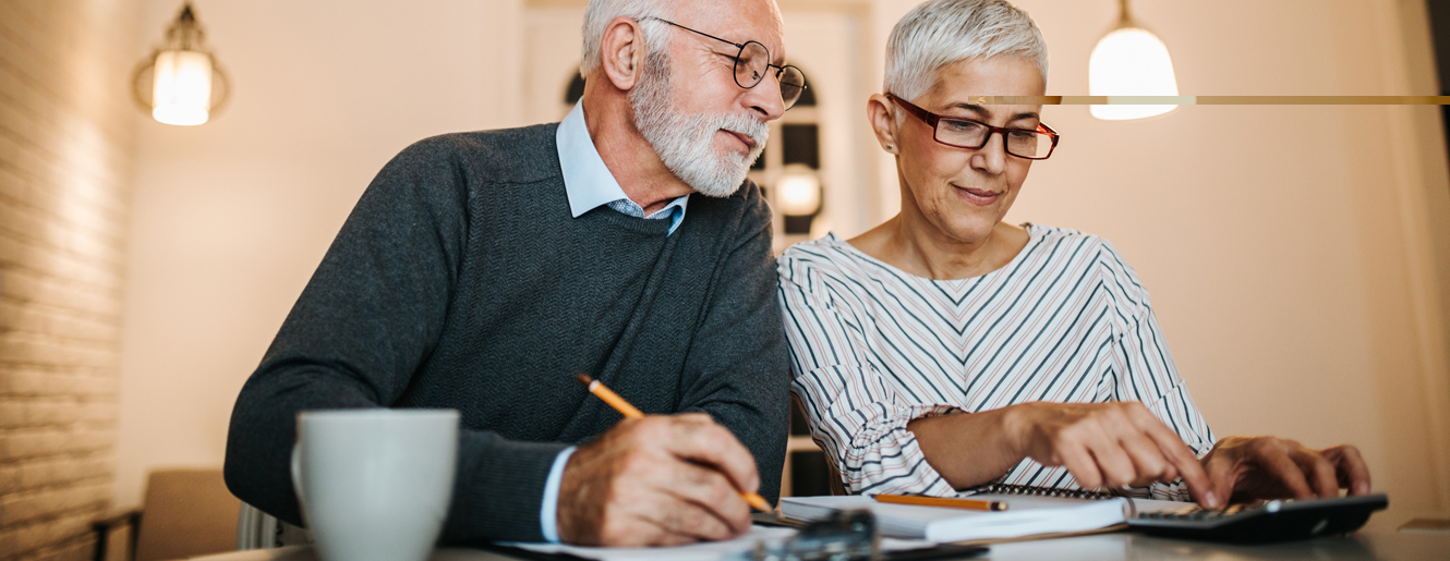 Mature couple sitting at a desk.